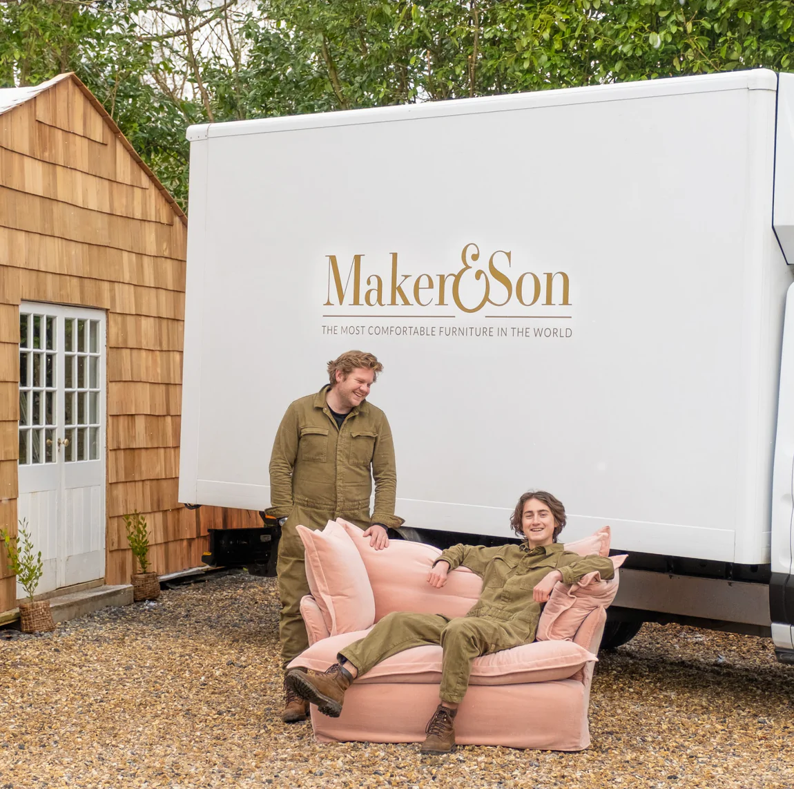 Maker and Son delivery team in front of a white branded truck sitting in a plaster pink velvet loveseat in Song pillow edge