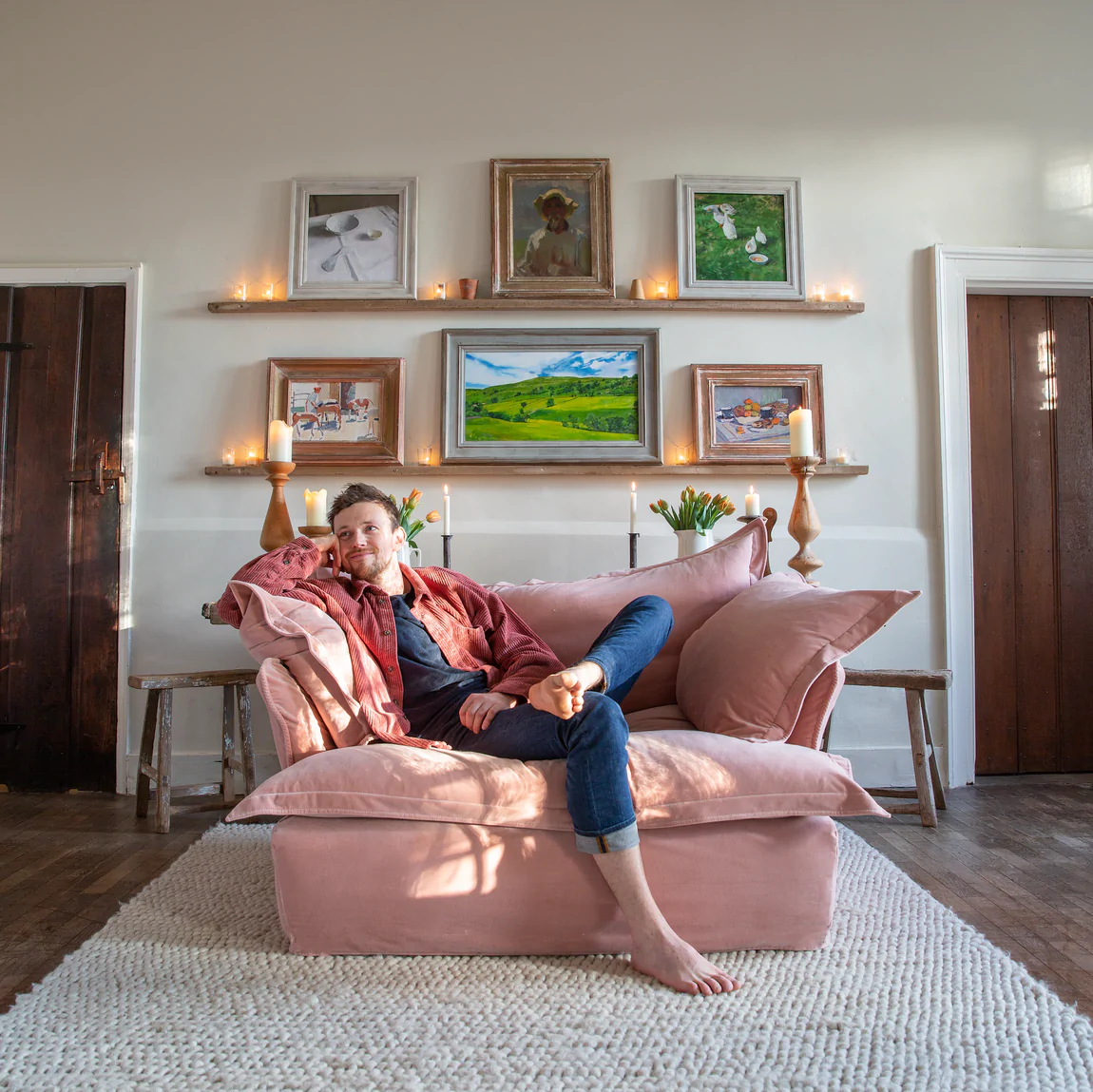 Freddie sitting on a MakerSon plaster pink velvet loveseat in Song pillow edge in Kemps House living room